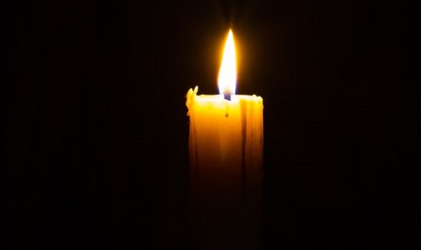 Lone candle burning in the darkness